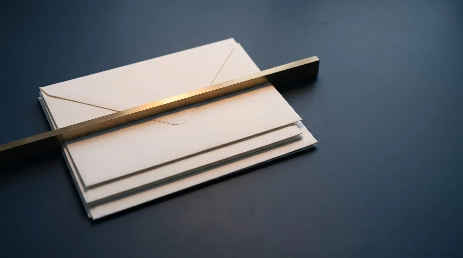 Stacked scholarship award envelopes under a brass ceiling.